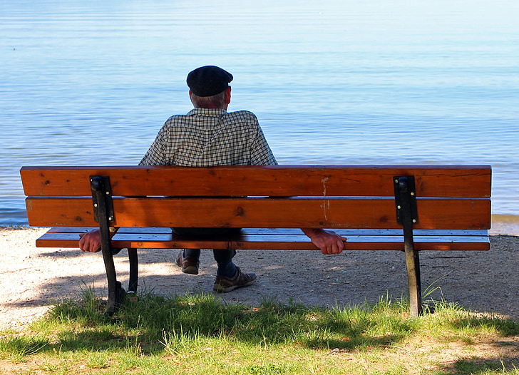 person sitting on brown wooden bench