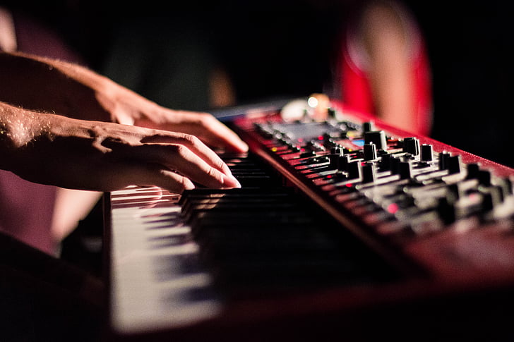 person playing red electronic keyboard