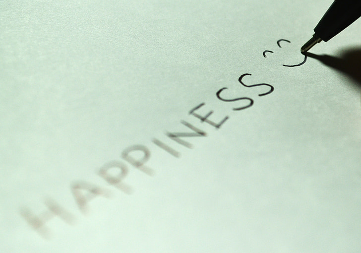 person writes happiness with smiley