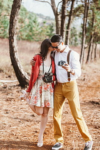 man holding camera and woman wearing land camera