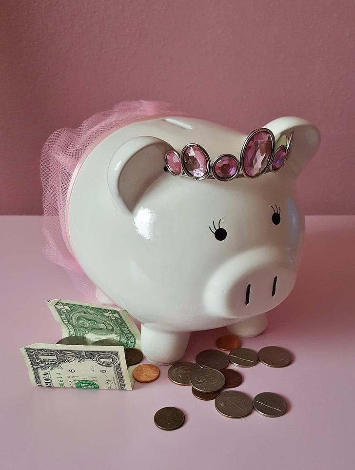 white ceramic piggy bank near coins and banknote