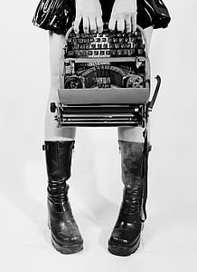 grayscale photograph of person holding type writer machine