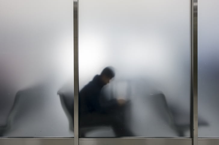 silhouette of man behind frosted glass window