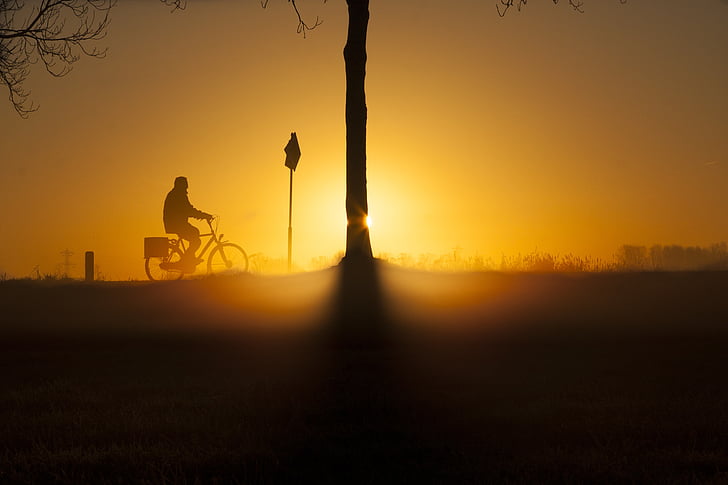 silhouette of person riding bicycle