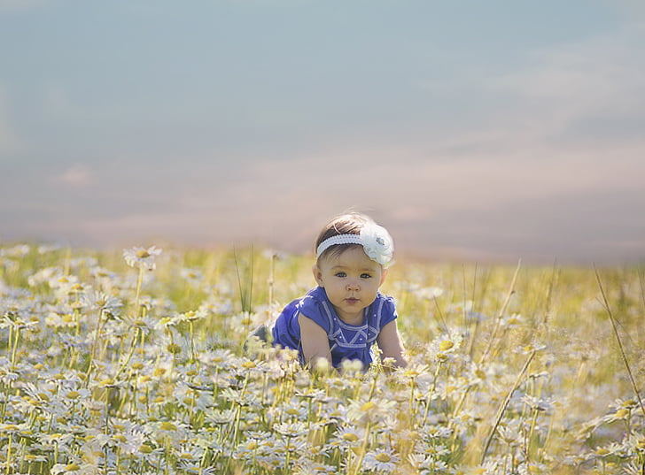 baby about to crawl and surrounded by flowers