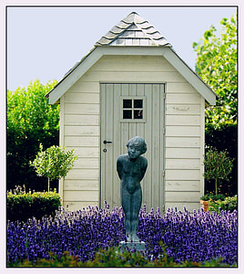 person statue near white wooden shed