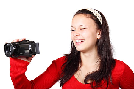 woman smiling while holding video camera