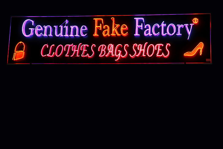 Genuine Fake Factory neon signage turned on