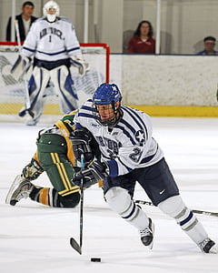 male ice hockey player skating together with puck