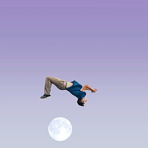 man in blue shirt and brown pants above moon