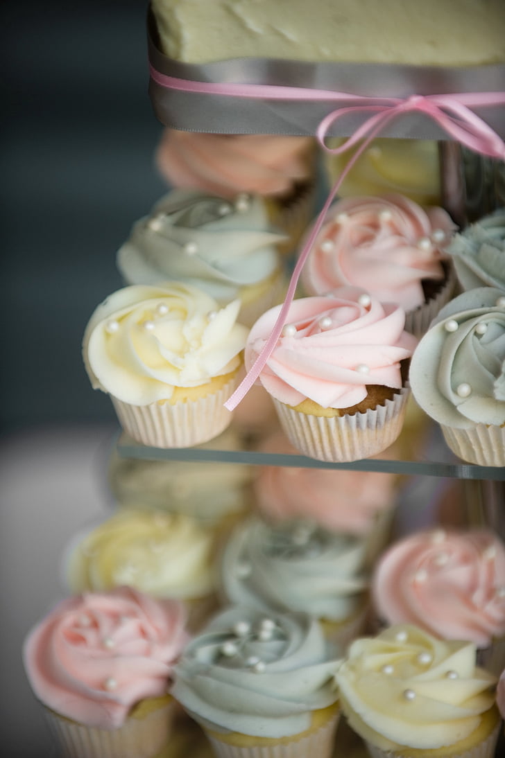 selective focus photography of cupcakes on glass shelf