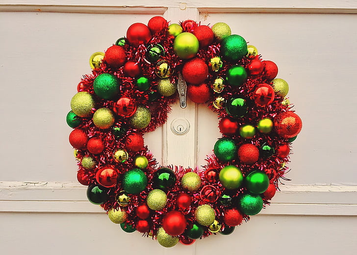 red, green, and gold bauble wreath hanged on white wall