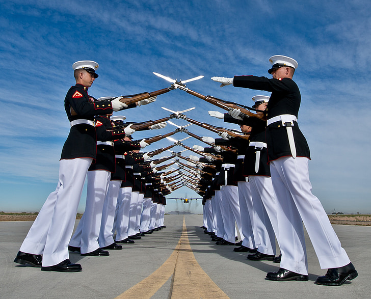 cadets forming two lines while their rifle crossed creating a dome pathway on airport photo