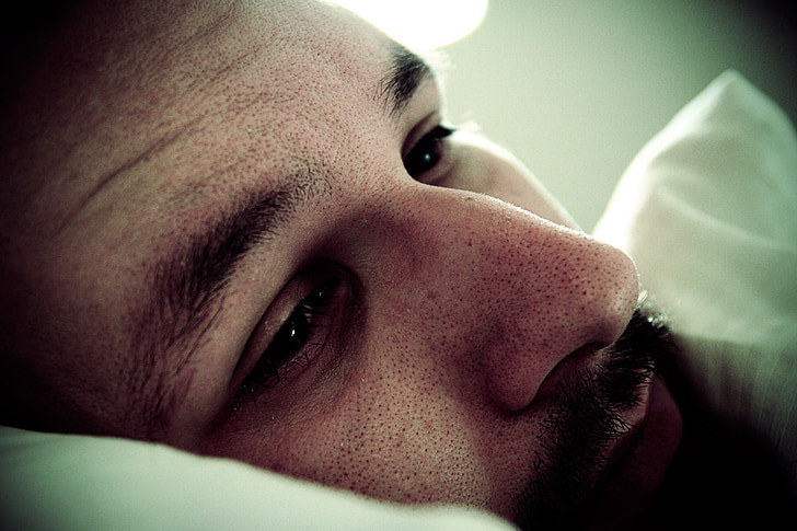 micro photograph of man lying on pillow