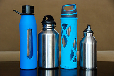four blue and gray tumblers on black wooden surface