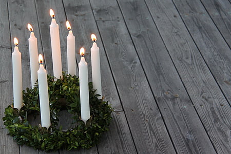 seven white candle sticks on green wreath