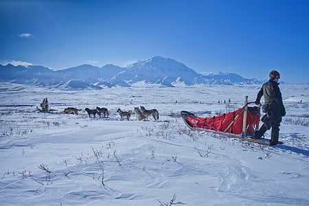 man riding on sled on snowfield