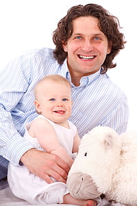 man holding baby wearing white sleeveless shirt beside white animal plush toy