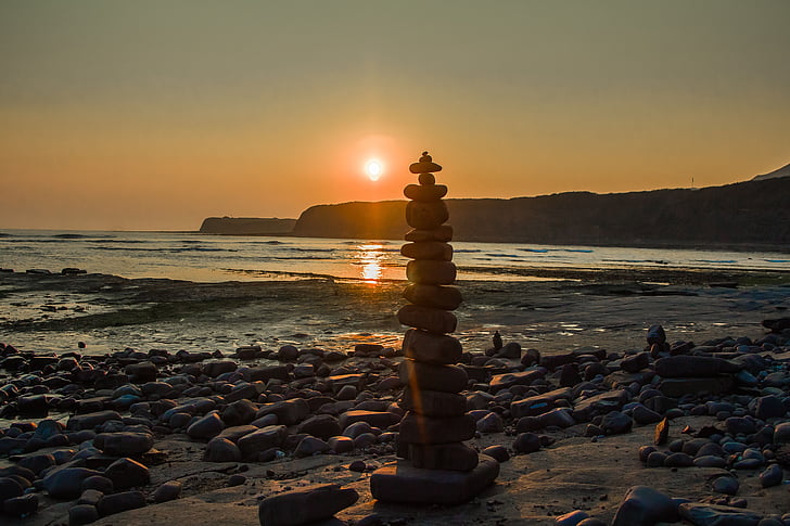 cairn on seashore during daytime