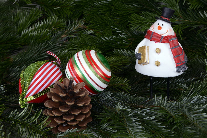 snowman bauble beside pine cone