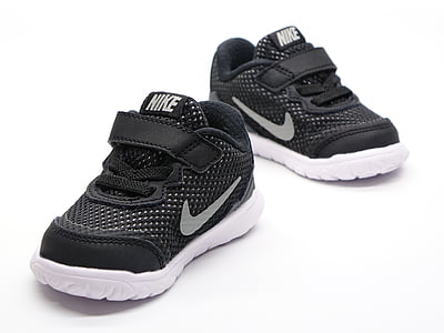 pair of toddler's black-and-white Nike sneaker on white surface