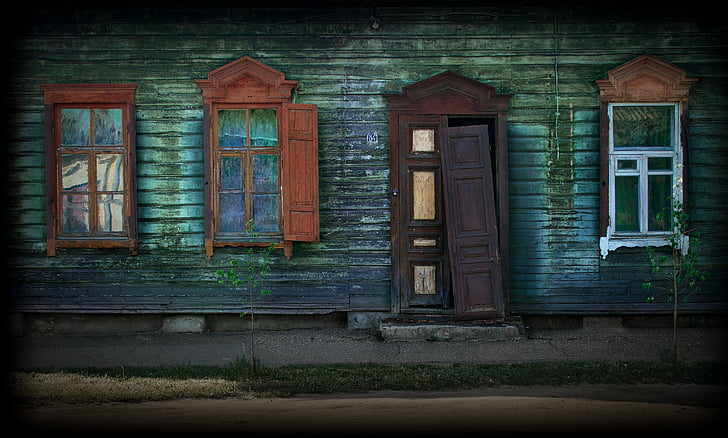 green wooden house with brown wooden door