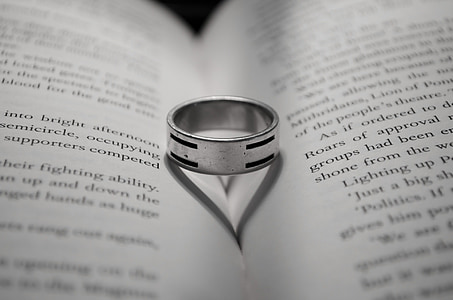 photo of silver-colored ring on book