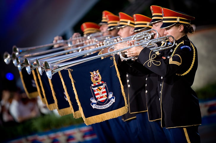 marching band using trombones with blue flags