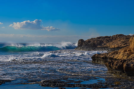 ocean waves hitting rocks during daytime