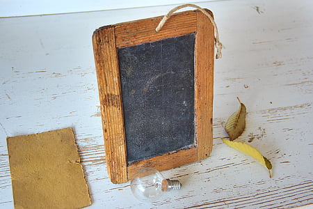 brown and black wooden photo frame near glass halogen bulb