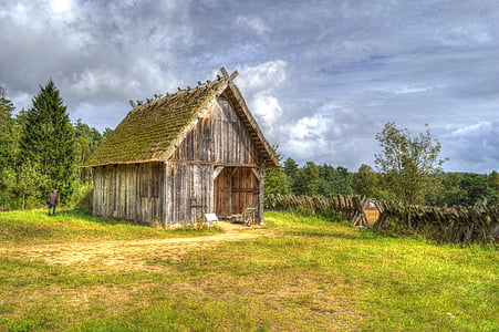 barn in the middle of the field surrounded by trees