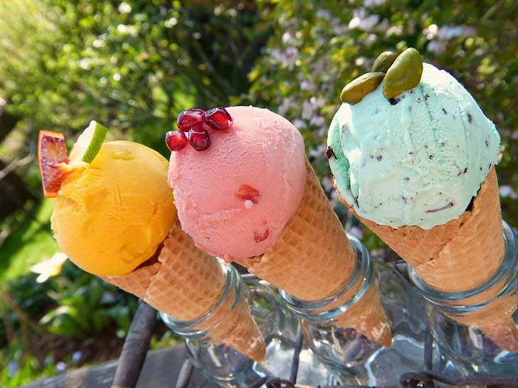 several ice-creams on sugar cones in glass jars