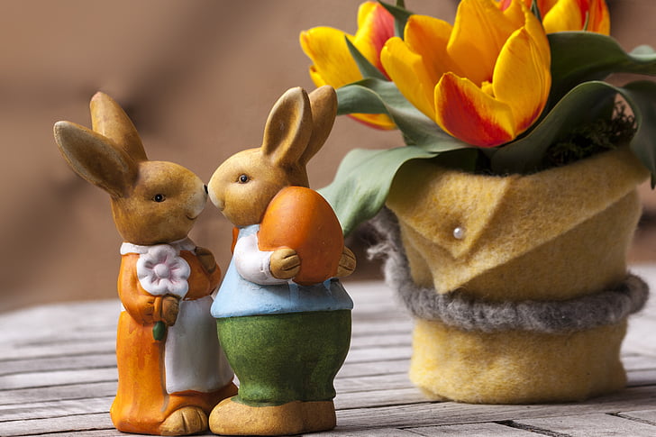 two brown rabbit figurines near yellow tulips flower centerpiece