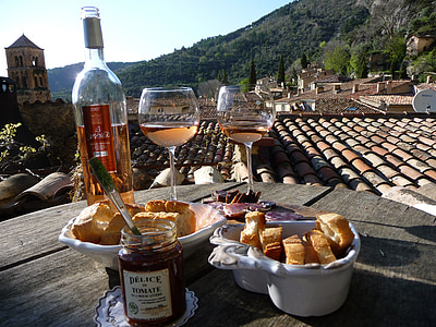 bowls of bread with two filled wine glasses, jam jar, and wine bottle