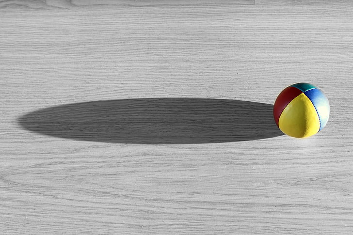yellow, red, and blue ball on gray wooden surface