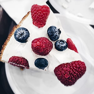 sliced white icing-covered cake with berries on top
