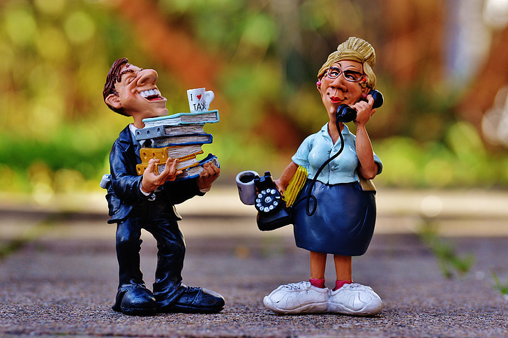 man holding books and woman using telephone figurines
