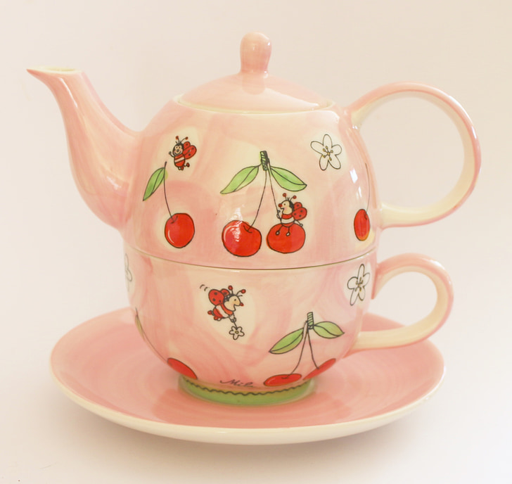 pink and red ceramic kettle on top of pink saucer