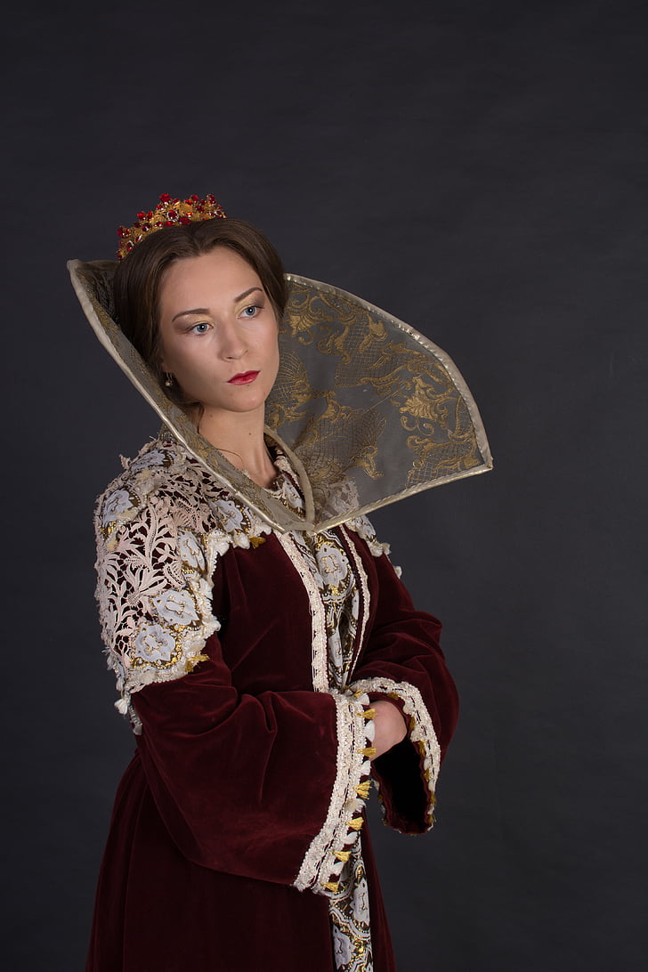woman wearing maroon dress with Elizabethan collar on neck