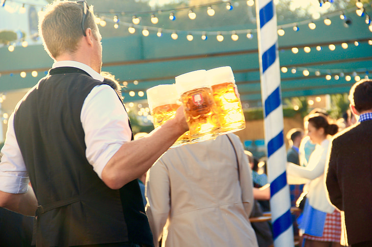 man holding beer mugs filled with beers