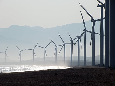 line of windmills in front of sea at daytime