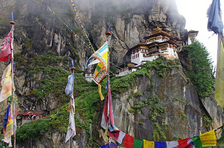 assorted-color flags near high top house near mountain