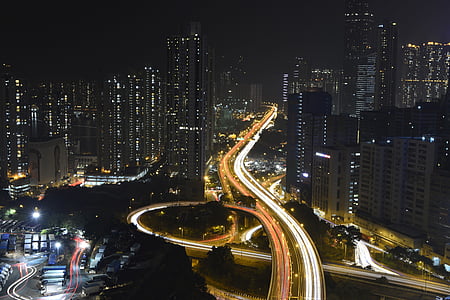 time lapse photography of road near buildings during night time