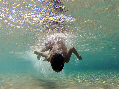 boy swimming during daytime