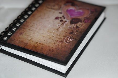 selective focus photography of brown spiral notebook