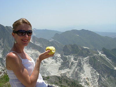 woman holding apple on top of mountain