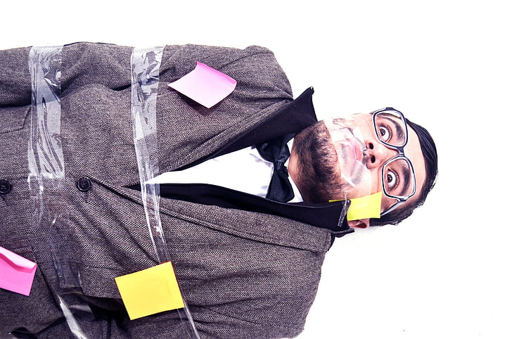man covered with adhesive tape and sticky notes