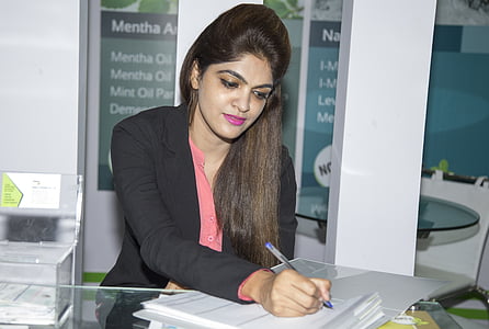 woman in black blazer writing on white paper