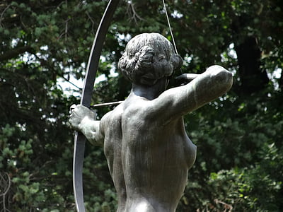 female archer statue near green leaf tree