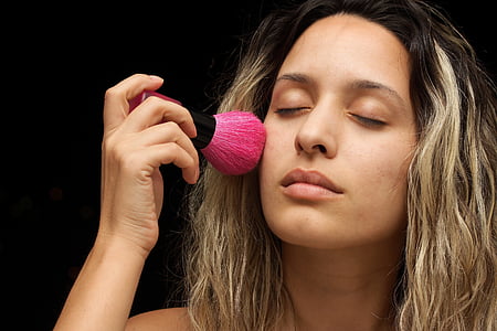 woman holding pink make-up brush